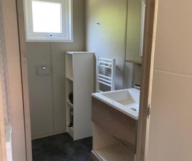 Salle de bain avec lavabo meuble et petite fenêtre du Chalet au calme dans la pinède