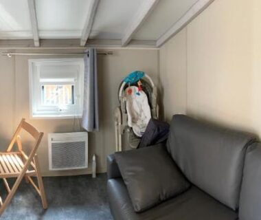Intérieur avec canapé, bureau et fenêtre du Chalet au calme dans la pinède