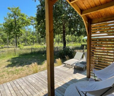 Terrasse en bois avec transats donnant sur la pinède du Chalet au calme dans la pinède