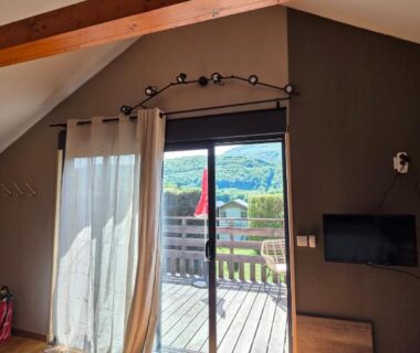 Intérieur avec baie vitrée donnant sur terrasse du Chalet avec piscine 2C