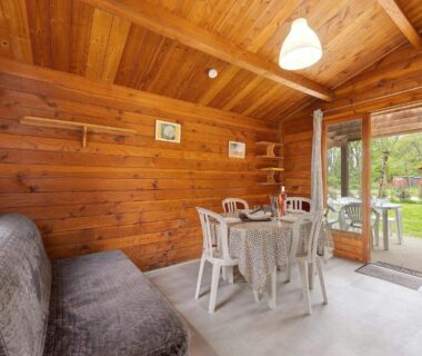 Intérieur en bois avec table et canapé dans le Chalet bois 8 Domaine Les Epinettes