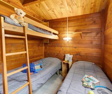 Intérieur de la chambre avec lits superposés et lits simples du Chalet bois 8 Domaine Les Epinettes
