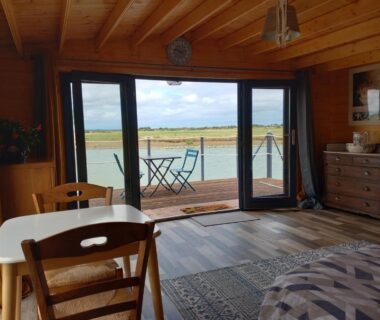 Intérieur avec baie vitrée et terrasse sur marais au Chalet chez le breton des marais