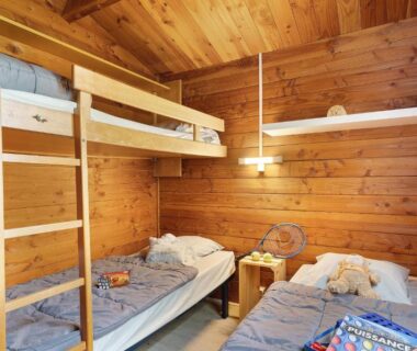 Chambre en bois avec lits superposés et lits simples dans le Chalet confort 21
