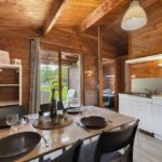 Intérieur en bois avec table à manger et kitchenette dans le Chalet confort 21