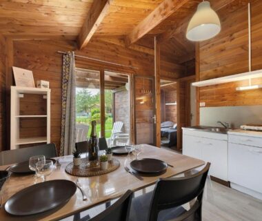 Intérieur en bois avec table à manger et kitchenette dans le Chalet confort 21