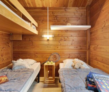 Chambre en bois avec deux lits et lit superposé dans le Chalet confort 21
