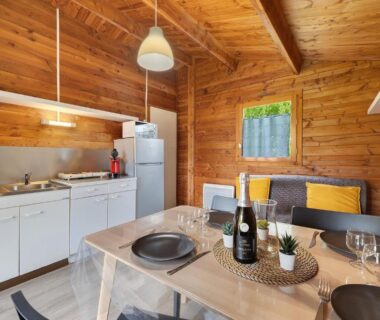 Intérieur du chalet en bois avec cuisine équipée et table dressée dans le Chalet confort 21