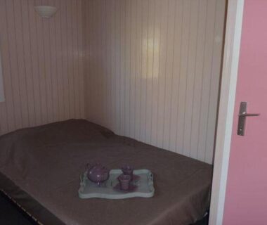 Chambre intérieure avec lit et plateau décoratif dans le Chalet confortable avec terrasse à Saint-Jean-de-Monts API-1-52-1184