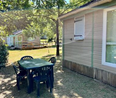 Terrasse ombragée avec table et chaises au Chalet cosy au cœur de la nature