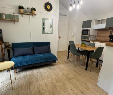 Salon avec canapé et coin repas dans le Chalet cosy au cœur de la nature