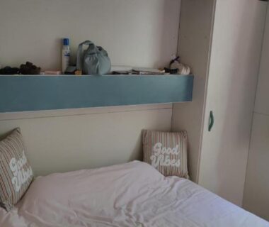 Chambre avec lit et étagère près de la fenêtre dans le Chalet dans Camping 3 étoiles à Vogüé