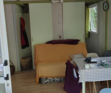 Intérieur du chalet avec banquette et table au Chalet dans Camping 3 étoiles à Vogüé