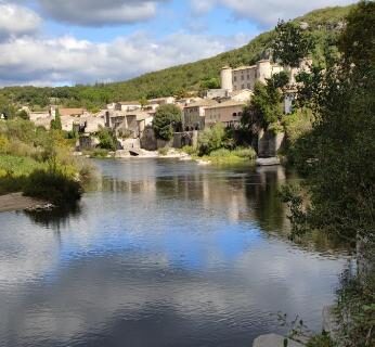 Rivière et village en hauteur au bord de l'eau dans le Chalet dans Camping 3 étoiles à Vogüé