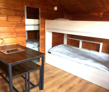 Intérieur du chalet avec lits superposés et table dans le chalet en bois Le Libellule