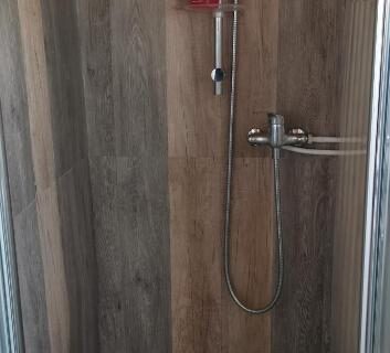 Cabine de douche en bois avec douchette dans le chalet Le Libellule