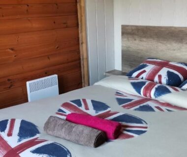 Chambre avec lit double et couette drapeau britannique dans le chalet en bois Le Libellule