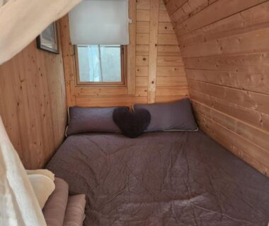 Chambre du chalet avec lit double murs en bois et fenêtre du Chalet en bois avec Jacuzzi Privé et Piscine