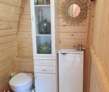 Salle d'eau en bois avec lavabo armoire miroir et WC dans le Chalet en bois avec Jacuzzi Privé et Piscine