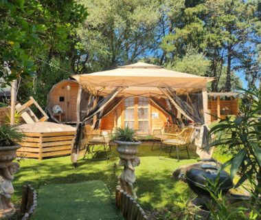 Jardin ombragé avec terrasse et fauteuils devant le Chalet en bois avec Jacuzzi Privé et Piscine