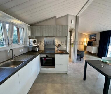 Intérieur cuisine ouverte avec table et salon dans le Chalet en bord de plage