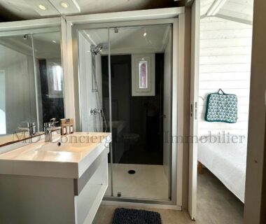 Salle de bains avec douche et lavabo dans le Chalet en bord de plage