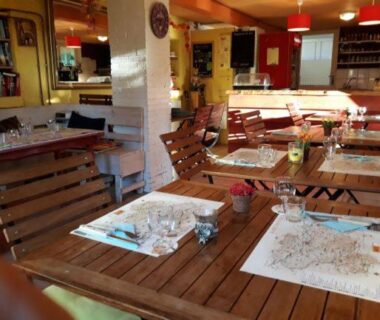 Salle à manger avec tables dressées au Camping les Sapins