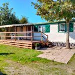 Terrasse en bois devant le mobil-home avec chaises au Chalet mobil-home