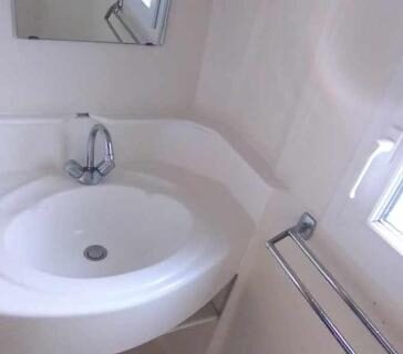 Salle d'eau avec lavabo et miroir dans le Chalet mobil-home