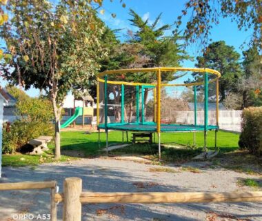 Aire de jeux avec trampoline et toboggan dans le camping du Chalet mobil-home