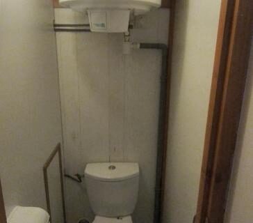 Salle d'eau étroite avec WC et chauffe-eau dans le Chalet mobil-home