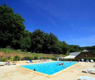 Piscine extérieure dans la nature avec transats au Chalet nature et lac dans parc résidentiel de loisirs