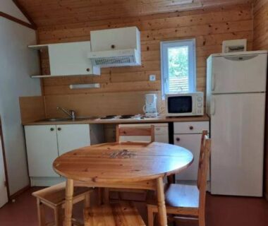 Cuisine et coin repas en bois dans le Chalet nature et lac dans parc résidentiel de loisirs