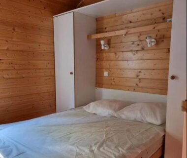 Intérieur chambre en bois avec lit double dans le Chalet nature et lac dans parc résidentiel de loisirs