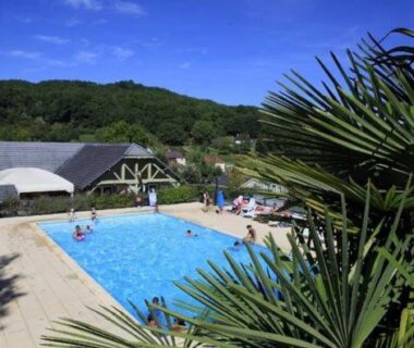 Piscine extérieure entourée de verdure dans la campagne corrézienne au Chalet nature et lac dans parc résidentiel de loisirs