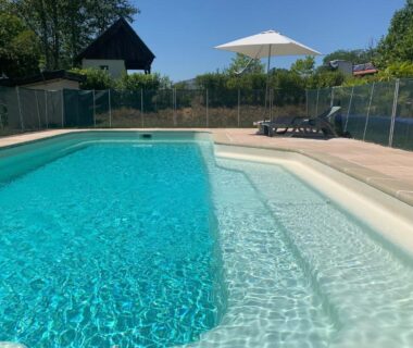 Piscine extérieure avec parasol et transats au camping Villa Mayari