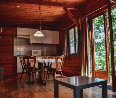 Intérieur de chalet en bois avec kitchenette et table près des fenêtres à la Villa Mayari