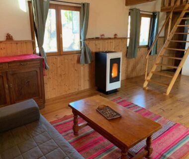 Intérieur salon avec poêle à granulés et mezzanine dans les Chalets & Camping Villa Mayari