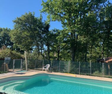 Piscine extérieure entourée d'arbres aux Chalets & Camping Villa Mayari