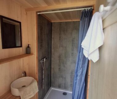 Salle de bain avec douche et serviettes dans les Chalets de l'Oasienne