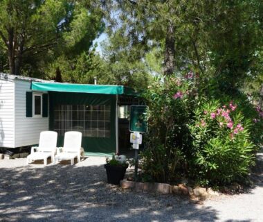 Mobil-home ombragé avec chaises et auvent aux Chalets met buitenkeuken op Camping Leï Suves JoyCasa