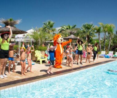 Bord de piscine avec mascotte enfants et chaises longues au Camping Leï Suves JoyCasa