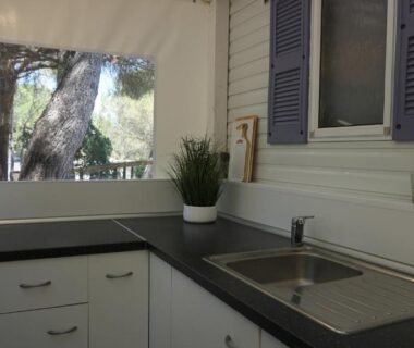 Coin cuisine avec évier et plan de travail dans le chalet Chalets met buitenkeuken op Camping Leï Suves – JoyCasa