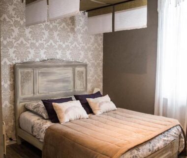Chambre avec lit double et tête de lit en bois aux Chambres d'hôtes Le Pessac.