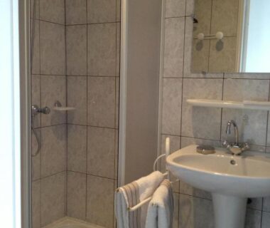 Salle de bain avec douche et lavabo aux Chambres d'hôtes Le Pessac