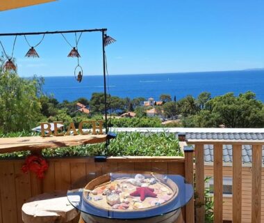 Terrasse avec table en bois et panorama marin du Charmant Mobil home avec Vue mer exceptionnelle