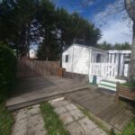 Terrasse en bois avec banc et mobil-home du Charmant Mobil-home proche de la mer