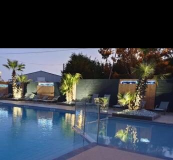 Piscine extérieure éclairée au crépuscule du camping Charmant Mobil-home proche de la mer