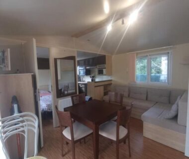 Salon avec coin repas et kitchenette dans le Charmant Mobil-home proche de la mer