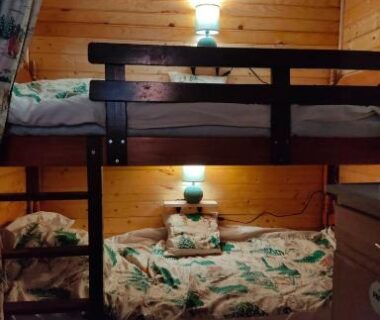 Intérieur avec lits superposés et lampe murale dans le Charmant Mobil home style chalet